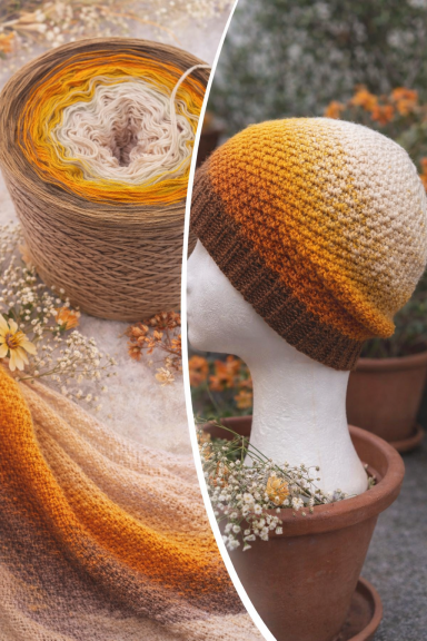 Hübsche Mütze in orange-weißem Farbverlauf, umgeben von Garn und Trockenblumen.