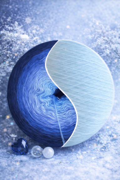 Blau-weiße Wollknäuel mit Glassteinen auf einer glitzernden, blauen Oberfläche.